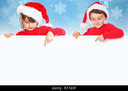 Weihnachten Kinder Kinder Weihnachtsmann zeigt leeren banner Schnee schneit copyspace Stockfoto