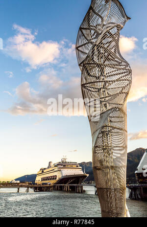 Metall abstrakte Skulpturen entlang Dock von Cruise Ship Port, mit Schiffen, die in Hintergrund angedockt ist, am späten Nachmittag warmes Sonnenlicht, Juneau, Alaska, USA. Stockfoto