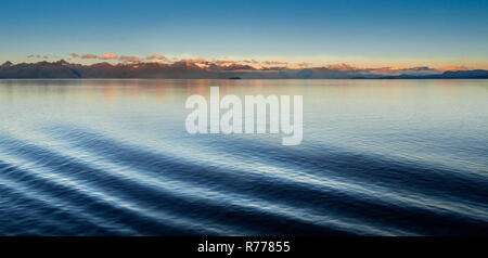 Schiff, Bow Wave ripples, Port Side, in der ruhigen Licht der Morgendämmerung mit Sonnenaufgang beleuchteten Berge. Stephen's Passsage, Alexander Archipel, Alaska, USA. Stockfoto