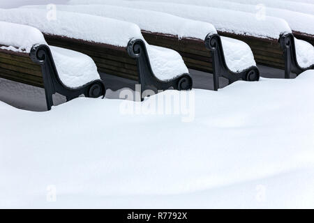 Holzbänke bedeckt mit weißen Schnee. Park nach starker Schneefall Stockfoto