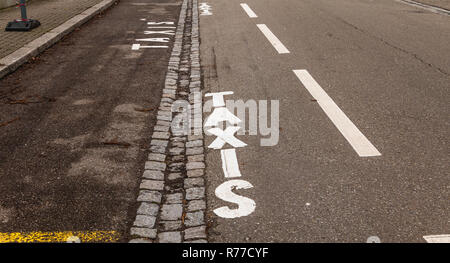 Weiß lackiert taxi Schild auf einem schwarzen Asphalt Stockfoto