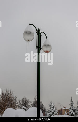 Straßenlaterne dangling Eisschollen verschneiten und kalten Wetter Stockfoto