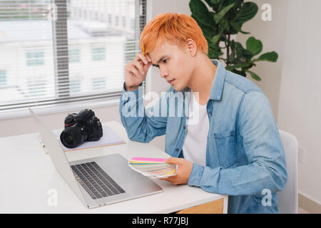 Nachdenklich Fotograf am Schreibtisch arbeiten in modernen Büros Stockfoto