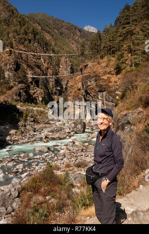 Nepal, Larja Dobhan, Senior weibliche Touristen an Larja Brücken über schnell fließenden Dudh Khosi Fluss Stockfoto