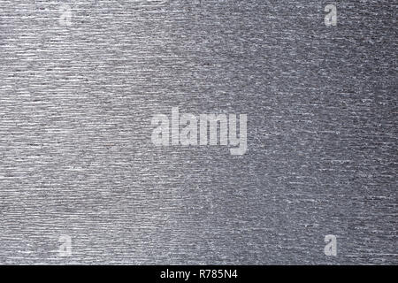 Die Textur der graue Folie Hintergrund der wellige Wellpappe, Nahaufnahme. Struktur der metallischen zerknittert Krepp silber Karton Makro. Stockfoto