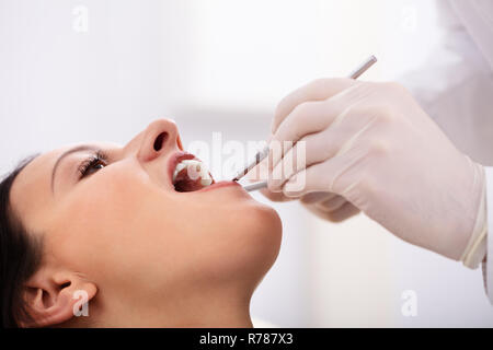 In der Nähe von Frau Zähne werden durch Zahnarzt mit zahnmedizinischer Spiegel und Scaler überprüft Stockfoto