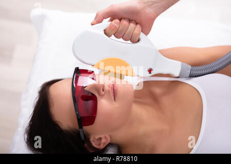 Close-up Kosmetikerin Hand, Laser Epilation Behandlung für junge Frau Gesicht Stockfoto