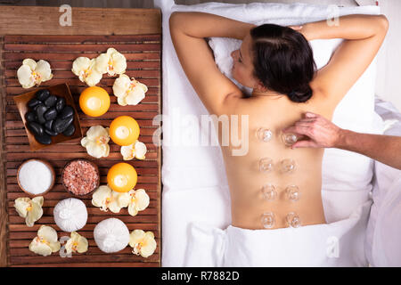 Entspannt junge Frau empfangen Schröpfen Behandlung auf Ihr zurück in Spa. Stockfoto