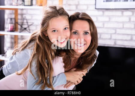 Portrait von Happy Reife Mutter geben Huckepack auf ihre Tochter Stockfoto