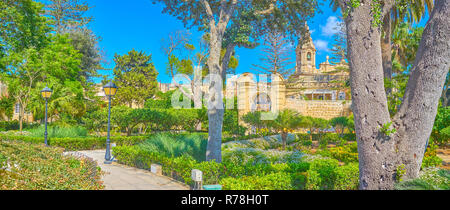 NAXXAR, MALTA - 14. Juni 2018: Die malerische italienische Gärten des Palazzo Parisio, auch bekannt als Scicluna Palace, mit schattigen grünen Bäume, Blumenbeete Stockfoto