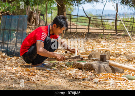 Don Daeng, Laos - 27. April 2018: Lokaler Mann Schneiden von Holz in einem abgelegenen wilde Gegend der ländlichen Laos Stockfoto