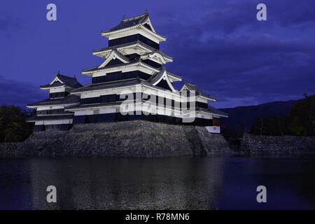 Matsumoto, Japan. Schloß Matsumoto (Crow Schloss, Fukashi Schloss) bei Nacht, koi Karpfen im Vordergrund. Stockfoto