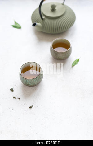 Asiatische Tee Set Keramik Teekanne und Teetassen mit grünem Tee. Traditionelle tee Zusammensetzung auf weißem Hintergrund, kopieren. Stockfoto