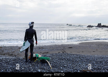Ama diver stehend auf einem Kieselstrand, Vorbereitung zum Tauchen, Mie, Japan Stockfoto