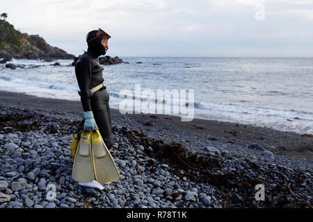 Ama diver stehend auf einem Kieselstrand, Vorbereitung zum Tauchen, Mie, Japan Stockfoto