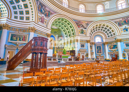 MOSTA, MALTA - 14. JUNI 2018: Im Innenraum der Basilika der Himmelfahrt der Jungfrau Maria mit schönen Holz geschnitzte Kanzel und Altar auf dem Hintergrund, o Stockfoto