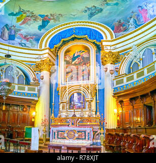 MOSTA, MALTA - 14. JUNI 2018: Der Marmor Altar der Basilika der Himmelfahrt mit bunten Fresken und aus Holz geschnitzte Stühle der ch eingerichtet Stockfoto