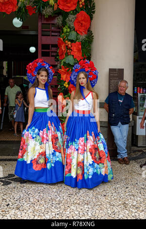 Zwei junge Frauen in bunten Versionen von Tradionellen Kostüm mit großen faltenröcke und blumig headpieces in Funchal auf Madeira Stockfoto