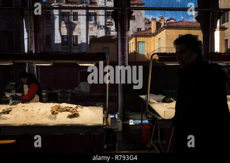 Venedig, Portugal - 9. Dezember 2017: Männer, die ein Fisch stand auf der Venedig Markt kaufen Stockfoto