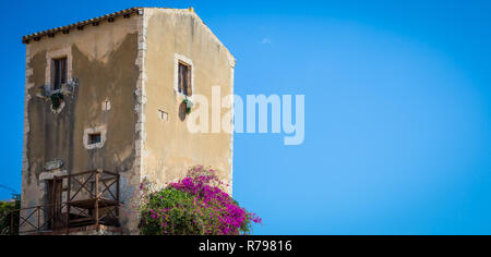 Sizilien, Italien. Altes Haus mit lila Blüten in Syrakus. Stockfoto