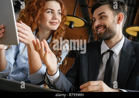 Geschäftsleute in Business Lunch im Restaurant sitzen unten Close-up Holding digital Tablet lächelnd Stockfoto