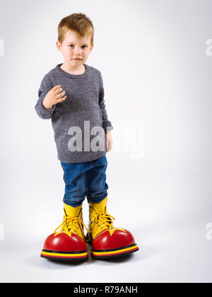 Foto eines Jungen tragen riesige Clown Schuhe. Stockfoto