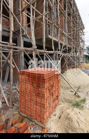 Palette der roten Ziegelsteine platzieren. Vor dem Haus im Bau Stockfoto