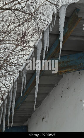 Gefrorenen Eiskristallen hängen vom Dach Stockfoto