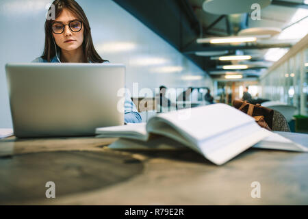 Frau in Brillen Arbeiten am Laptop am College Campus sitzen. Weibliche Studenten studieren an der Universität. Stockfoto