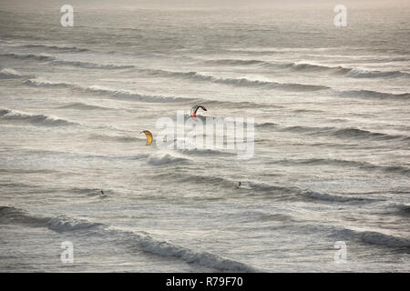 Kite Surfer im rauhen Meer und Wellen vor der Küste von Devon, Großbritannien Stockfoto