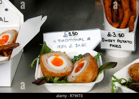 Scotch Ei auf Stall mit Schweinefleisch und Salbei Füllung und Süßkartoffelfrites zum Verkauf am Borough Market in London England Großbritannien KATHY DEWITT Stockfoto