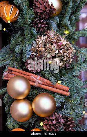 Gold Weihnachtskugeln, Zimtstangen, Orangenschale und getrocknete Hortensien auf Fir Tree Branches Kranz in der City von London England UK KATHY DEWITT Stockfoto