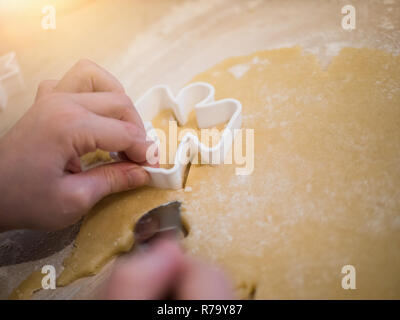 Weihnachtsbäckerei: Blick von oben auf ein Mädchen Vorbereitung Cookies in Engel Form Stockfoto