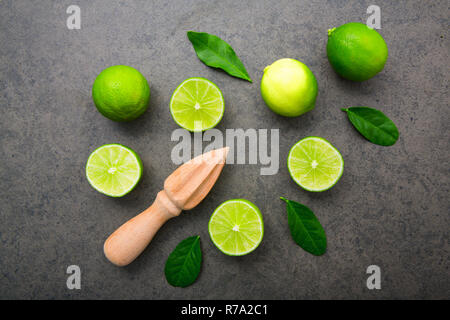 Frische Limonen und Holz- entsafter auf weißem Hintergrund. Ansicht von oben mit der Stockfoto