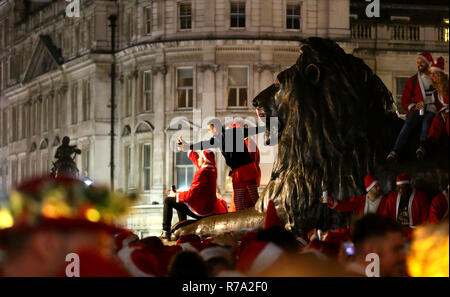 Menschen in Santa Kostüme auf dem Trafalgar Square, London, als sie an Santacon London 2018. Stockfoto