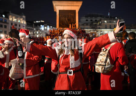 Menschen in Santa Kostüme auf dem Trafalgar Square, London, als sie an Santacon London 2018. Stockfoto