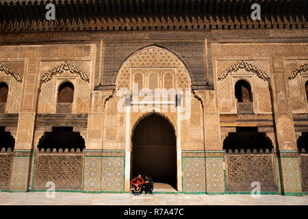 Marokko, Fes, Fes el Bali, Medina, talaa Seghira, Medersa Bou Inania, junge Touristen saßen in Tür Stockfoto