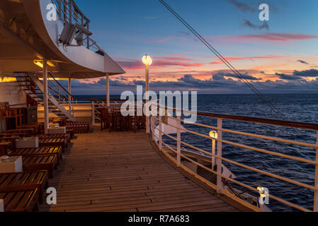 Indischer Ozean - Januar 31, 2018. Weitwinkel Foto vom Deck eines Kreuzfahrtschiffes berücksichtigt, da sie Segel im Indischen Ozean vor der Küste von Mauritius in der Abenddämmerung. Stockfoto