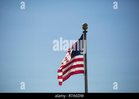 Amerikanische Flagge kräftig winken im Wind vor blauem Himmel Stockfoto