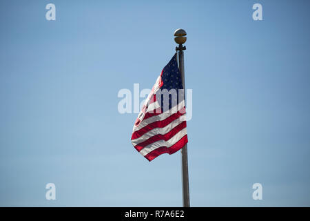 Amerikanische Flagge kräftig winken im Wind vor blauem Himmel Stockfoto