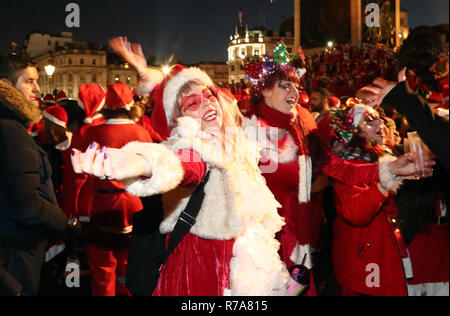 Menschen in Santa Kostüme auf dem Trafalgar Square, London, als sie an Santacon London 2018. Stockfoto