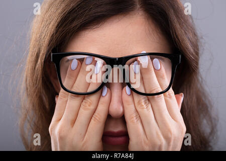 Nahaufnahme einer jungen Frau mit Brille, die Ihre Augen Stockfoto