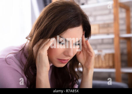 Nahaufnahme einer schönen jungen Frau leidet unter Kopfschmerzen. Stockfoto