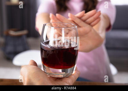 Nahaufnahme von einer Frau die Hand weigert Glas trinken Angeboten durch Person Stockfoto