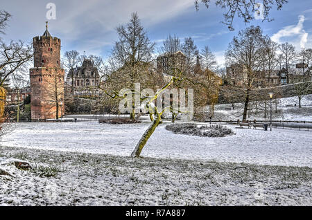 Kronenburg Park in downtwon Nijmegen, Niederlande, mit dem mittelalterlichen Pulverturm, bedeckt mit einer dünnen Schicht von frischem Schnee an einem kalten Tag im Wint Stockfoto