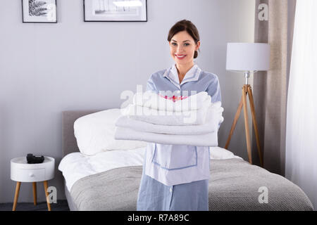 Portrait eines glücklichen jungen Frau mit Stapel weiße Handtücher Stockfoto