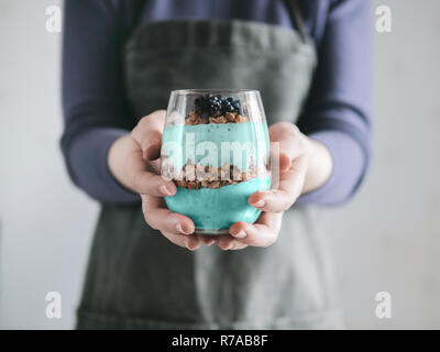 Spirulina Smoothie und Müsli in Frau Hände Stockfoto