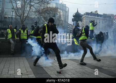 Paris, Frankreich. 8. Dezember 2018. Gelb (Gilets jaunes) Demonstranten Tränengas Kanister der Polizei werfen während eines Protestes gegen die Lebenshaltungskosten und die steigenden Ölpreise Credit: Piero Cruciatti/Alamy leben Nachrichten Stockfoto