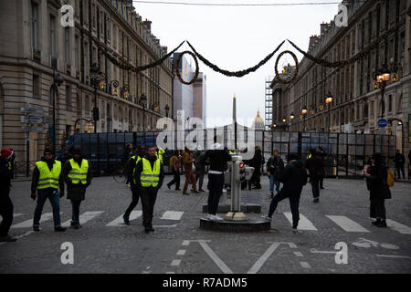 Paris, Frankreich, 8. Dezember, 2018. Die Demonstranten tragen gelbe Westen in der Nähe von Polizei Straßensperre sperren Zugriff de la Concorde, rue Royale, Paris. Rund 10.000 Demonstranten in gelben Westen in Paris für das vierte Wochenende in einer Reihe demonstrierten gegen Steuern auf Kraftstoff und Rückgang der Kaufkraft zu protestieren. Sicherheit wurde verstärkt, als vorherige Woche Proteste gewalttätiger geworden. Credit: Christelle Chanut/Alamy leben Nachrichten Stockfoto