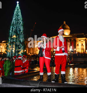 London, Großbritannien. 8. Dezember 2018. Nachtschwärmer steigen auf dem Trafalgar Square während der jährlichen Santacon Ereignis. Als Santa Claus, Elfen oder ähnliche Zeichen, das Festive Fun auch hebt Geld für Nächstenliebe gekleidet. Gruppen von verschiedenen Orten in der Hauptstadt früh am Tag auf dem Platz zu versammeln. Credit: Stephen Chung/Alamy leben Nachrichten Stockfoto